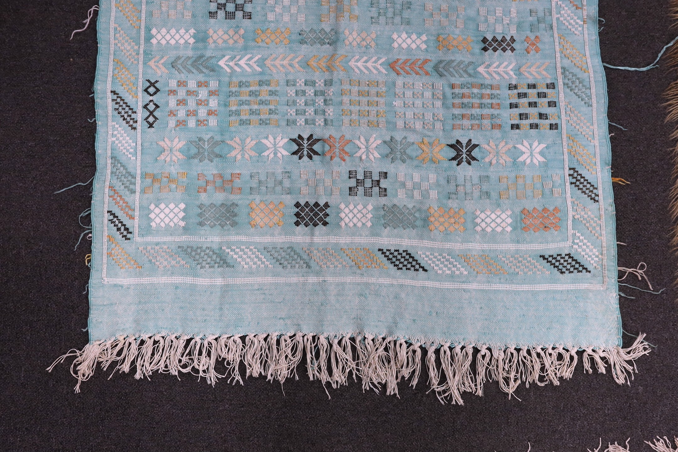 A turquoise rug, possibly Scandinavian